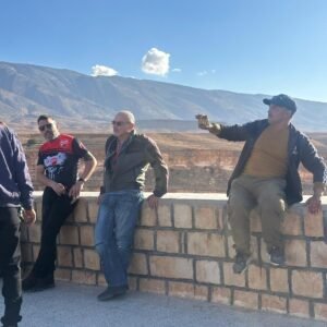Tamanrasset tour: travellers at a mountain viewpoint over the volcanic plain of the Hoggar, southern Algeria